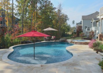 Pool in backyard with red umbrella - Dave Severance