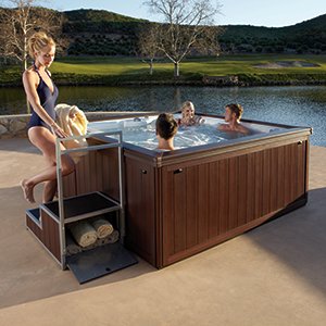 Friends in brown hot tub with lake in background
