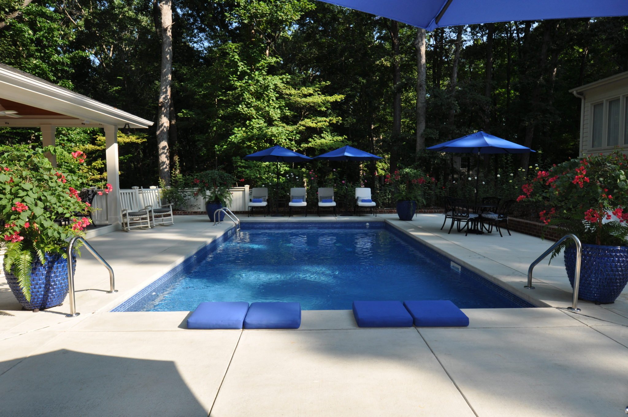 Rising sun pools and spas backyard pool with chairs and umbrellas
